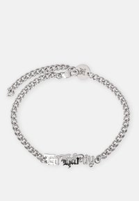 Sølvkjede armbånd med dobbel lagdesign og et dekorativt tekstsenter, sikret med en lås og gravert merke.