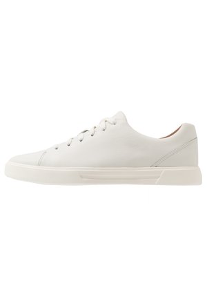 Lavtop hvid lædersneaker med snørelukning og tekstureret gummisål, vist i sideprofil på en hvid baggrund.