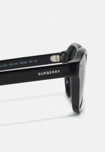 Occhiali da sole neri con finitura lucida, montatura rettangolare e il nome del marchio "Burberry" inciso sul braccio. Il design è elegante e moderno.