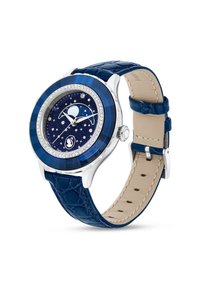 Srebrny zegarek z okrągłą niebieską obręczą i tarczą przypominającą nocne niebo. Skórzany pasek w ciemnoniebieskim kolorze z teksturą skóry krokodyla. Kryształowe akcenty wokół tarczy.