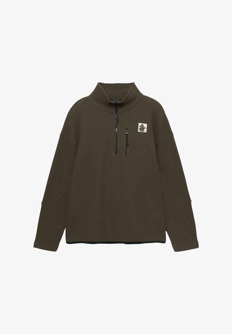 Oliwkowy, pulower o fakturze waflowej z wysokim kołnierzem i zapinanym z przodu na zamek. Posiada małą łatkę na klatce piersiowej oraz szerokie rękawy.