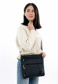 Borsa a tracolla nera, testurizzata, con chiusure a zip, tracolla regolabile e logo in evidenza. Design compatto per un uso quotidiano.