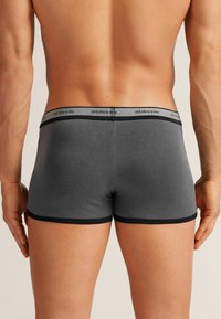 Szare bawełniane bokserki z czarnym elastycznym pasem, z logo. Dobrze dopasowane, z prostym przeszyciem i bez widocznych wzorów.