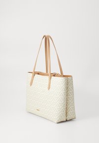 Sac fourre-tout en crème avec un motif géométrique beige. Il dispose de deux anses en cuir beige, d'une fermeture éclair, d'une forme rectangulaire et d'une texture lisse.