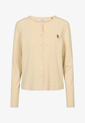 Beige ribbineuloksinen, pitkähihainen nappikiinnitteinen neulepaita, jossa pyöreä pääntie ja pieni kirjailtu logo vasemmassa rinnassa.