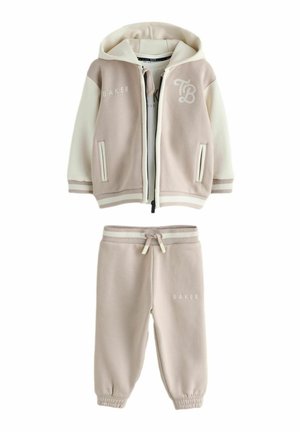 Helebeež kapuutsiga jakk ja sobivad püksid pehmest kangast; neil on valged detailid, logod ja elastsed varrukapõhjad koos tõmblukuga vöökohal.