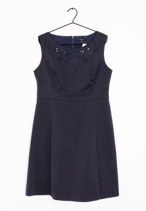 Ærmeløs navy kjole med blomsterudsmykninger og palietter langs rund halsudskæring, hængende på sort bøjle mod hvid baggrund.
