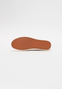 Gummisål til sneakers i brunt med et struktureret diamantskema, flad design og hvid kant. Har en glat overflade og robust konstruktion.