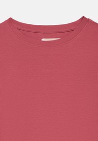 Κόκκινη ριμπ μπλούζα με στρογγυλή λαιμόκοψη. Το ύφασμα έχει υφή με ανάγλυφη επιφάνεια και ομοιόμορφο χρώμα σε όλο το μήκος.