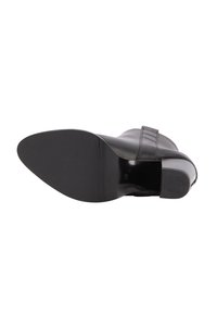 Botină din piele neagră, văzută din talpă, care arată talpa din cauciuc netedă și toc mic cu vârf texturat. Mărimea 38.