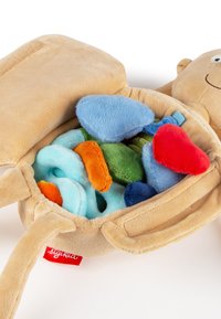 Soft beige plush doll with a smiling face, open torso revealing removable colorful plush organs inside.