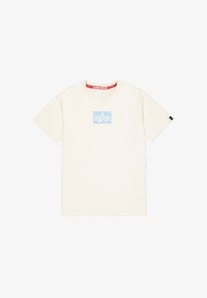 Cremfarbendes Baumwoll-T-Shirt mit kurzen Ärmeln, verziert mit einem hellblauen quadratischen Logo, auf dem in sanften Buchstaben "ALPHA INDUSTRIES" steht.