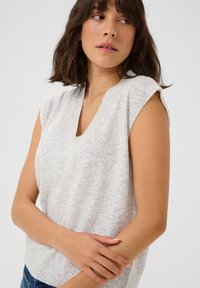 Pull sans manches gris clair avec un col en V, texture douce, ourlet côtelé et motif légèrement moucheté. Conception en tricot léger.