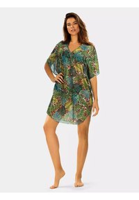 Przezroczysta narzutka z nadrukiem tropikalnych liści w odcieniach zieleni i brązu, krótki rękaw, dekolt w serek oraz luźny, zwiewny fason.