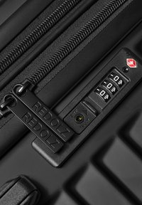 Maleta negra con cremallera y tiradores dobles etiquetados como "REDOLZ" y un candado de combinación TSA integrado configurado en 0-0-0.