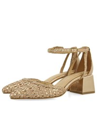 Pompes en cuir tissé beige avec des bouts pointus, une sangle à la cheville et des talons blocs dorés. Surface texturée et design minimaliste.