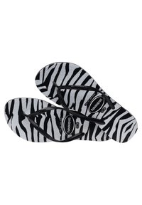 Infradito a strisce zebrate in bianco e nero con cinturini in gomma nera e suole strutturate. Logo Havaianas sulla scarpetta. Design leggero.