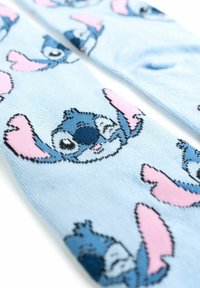 Calzini azzurri chiari con un motivo ripetuto di un personaggio stilizzato blu con orecchie rosa, che mostrano una morbida trama a maglia.