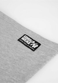 Grijze sportieve sweatshirtstof met een zwart rechthoekig logo-label met de tekst "GORILLA WEAR UNITED STATES OF AMERICA."