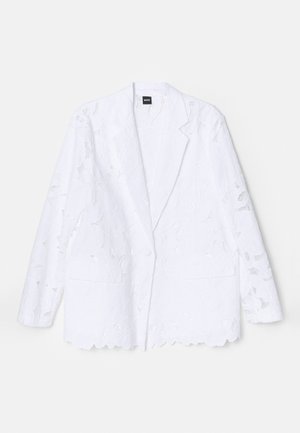 White blazer with floral lace design, single button closure, notched lapels, two front pockets, and scalloped hem detail.