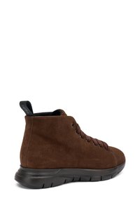 Zapatilla alta de ante marrón con cordones oscuros, suela de goma negra y una pestaña en el talón. Textura suave con un diseño minimalista.