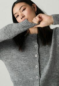 Gray knitted cardigan with a round neckline, ribbed cuffs, and six buttons down the front. Soft texture with a slightly relaxed fit.