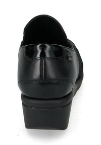 Scarpa nera in pelle con una superficie liscia, tacco arrotondato e un accento lucido sul retro. Presenta un design slip-on per un facile utilizzo.