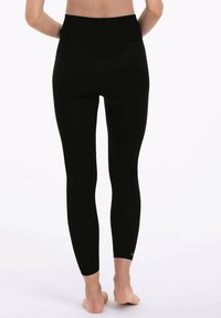 Black high-waisted leggings with a smooth texture and fitted design, extending to the ankles. Features a subtle logo on the lower leg.