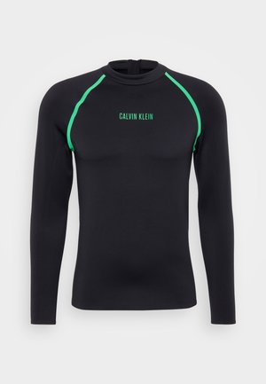 Fekete, hosszú ujjú rash guard zöld kiegészítőkkel. Magas gallérral és hátul cipzárral rendelkezik. Elöl zöld "Calvin Klein" logóval.