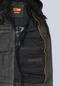 Schwarze Slim-Fit-Lederjacke, geöffnet, um das Innere mit orangener Paspelierung, Reißverschlusstaschen und dem Markenetikett von Emilio Adani zu zeigen.