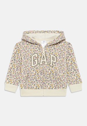 Felpa con zip a motivo floreale in crema con accenti gialli, rosa e verdi. Presenta il logo "GAP" davanti e un interno morbido e strutturato.