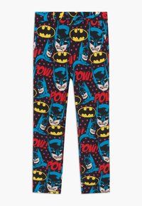 Leggings met een stripstijl ontwerp met Batman gezichten, gele logo's en kleurrijke "Pow!" tekst op een zwarte stippen achtergrond.