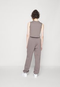 Gray sleeveless top paired with gray sweatpants, both in a soft fabric. The outfit features a relaxed fit and elastic waist for comfort.