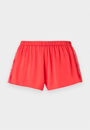 Shorts pour femmes rouge corail vif avec taille élastique et détails en dentelle le long des côtés, présentés à plat sur un fond gris clair.