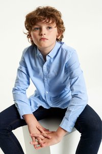 Heledad sinine särk, millel on punktkaelus, pikad varrukad ja valged nööbid. Kandmine tumedate teksadega. Lihtne, sile tekstuur.