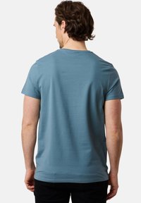 Jasnoniebieski t-shirt z krótkimi rękawami, wykonany z miękkiego materiału, z klasycznym okrągłym dekoltem i luźnym krojem, pokazany od tyłu.