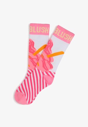 Chaussettes roses et blanches avec un motif floral, des accents orange et des rayures horizontales au niveau des orteils. Texte "BLUSH" en jaune en haut.