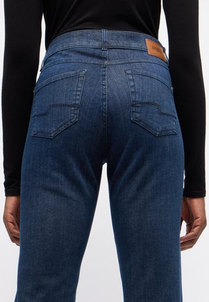 Blaue Denim-Jeans mit einer hohen Taille, ausgestattet mit zwei Gesäßtaschen und einem braunen Lederlogo-Patch am Bund. Weiches Stoffgefühl.