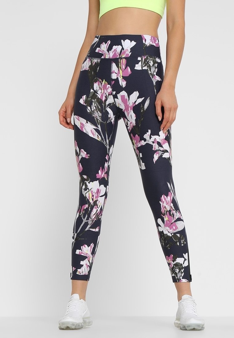 Námořnické legíny s květinovým vzorem, které obsahují velké růžové a bílé květy. Vyrobené z elastického materiálu s vysokým pasem a délce po kotníky.