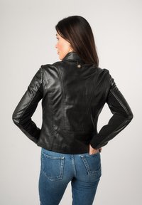 Zwarte leren jacket met een fitted ontwerp, rechtopstaande kraag en zichtbare stiksels. De achterkant heeft een decoratieve knop en naadloze mouwen.