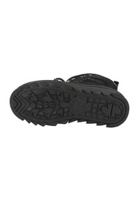 Černá gumová podrážka boty s drsným dezénem vzoru hvězdiček a vyvýšeným centrálním logem. Strukturální povrch pro lepší grip.