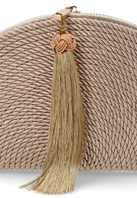 Bolso de mano tejido en color beige con una superficie texturizada, que presenta un borlón y un acento de nudo en dorado. Tiene un cierre de cremallera en la parte superior.