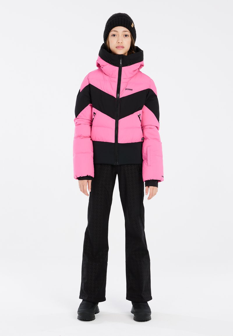 Doudoune rose et noire avec un design en chevrons, dotée d'un col haut et d'une fermeture éclair à l'avant. Pantalon noir avec une texture en pied-de-poule, associé à des bottes noires.