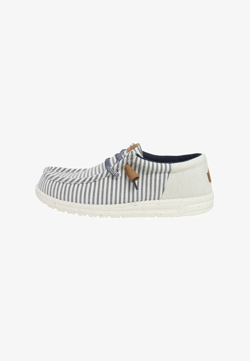 Scarpa slip-on in tela con righe blu navy e bianche, punta rotonda, suola bianca maculata e un nodo decorativo con un accento in pelle naturale.
