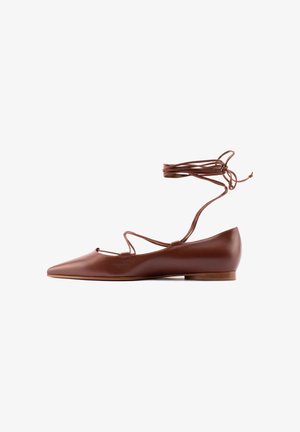 Ballerina marrone in pelle con punta a punta, lacci alla caviglia avvolgenti e tacco basso in legno, mostrata di profilo su sfondo bianco.