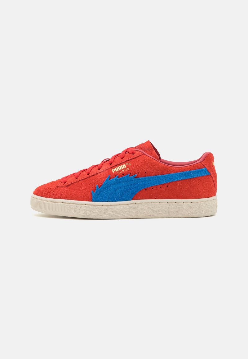 Basket Puma en daim rouge bas avec bande bleue dentelée et semelle beige, vue de côté.