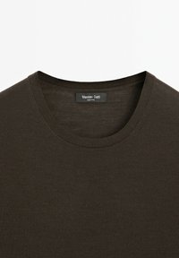 Tmavě olivově zelené bavlněné tričko s kulatým výstřihem, jemně žebrovanou strukturou a značkovou etiketou "Massimo Dutti" přišitou uvnitř límce.