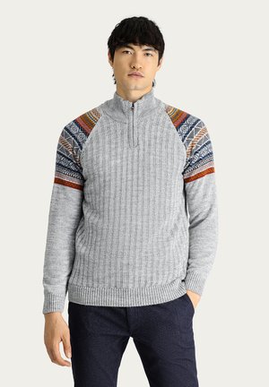 Sudadera de punto gris con cuello con cremallera, que presenta detalles con patrones en azul, naranja y rojo en los hombros. Puños y dobladillo acanalados.