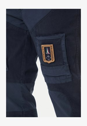 Pantaloni da lavoro blu scuro realizzati in tessuto resistente, con una tasca applicata e un distintivo ricamato con accenti tricolori.