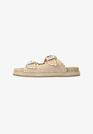 Beige suède instapsandalen met dubbele verstelbare gespen, gegolfde randen en een gewatteerd tussenzool met een rubberen buitenzool.